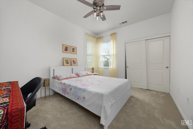 carpeted bedroom featuring visible vents, baseboards, a closet, and a ceiling fan