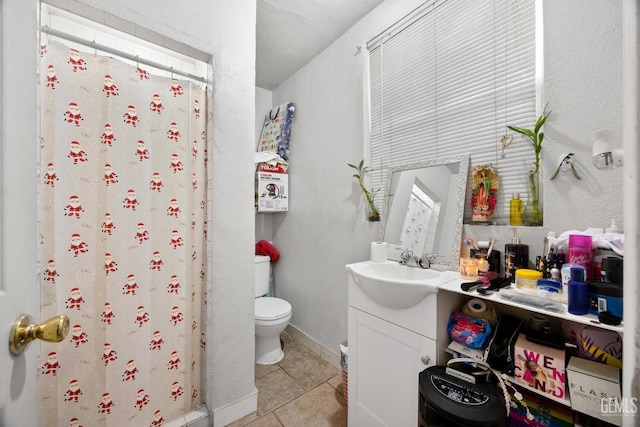 bathroom with vanity, tile patterned flooring, toilet, and walk in shower