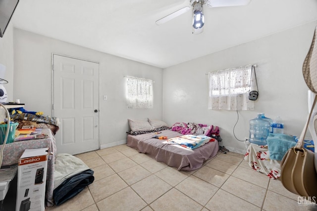 tiled bedroom with multiple windows and ceiling fan