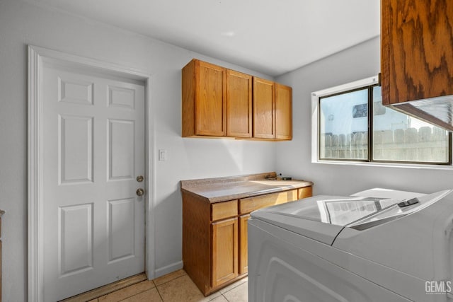 laundry room with cabinet space, light tile patterned floors, and washing machine and dryer