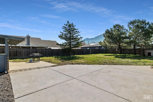 view of patio / terrace featuring a fenced backyard, a mountain view, and a grill