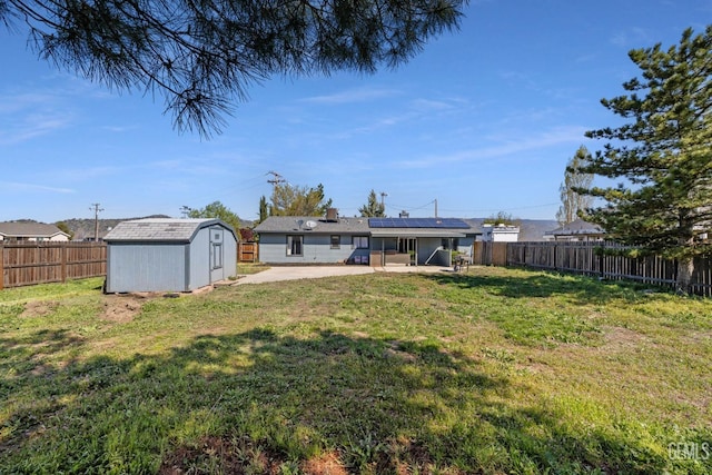 view of yard featuring a fenced backyard, a patio, an outdoor structure, and a shed