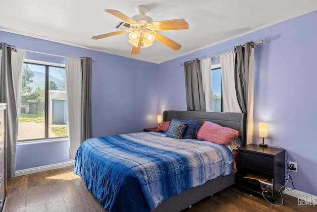 bedroom with a ceiling fan, baseboards, dark wood finished floors, and visible vents