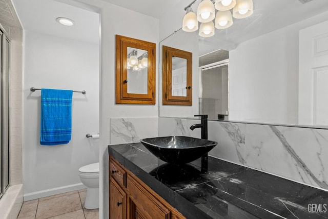 bathroom with toilet, a shower with door, a notable chandelier, and vanity