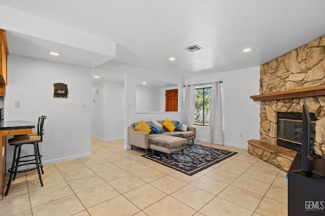 living room with recessed lighting, visible vents, light tile patterned floors, and a fireplace