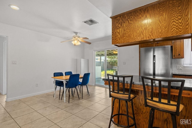 dining room with light tile patterned floors, baseboards, ceiling fan, and visible vents