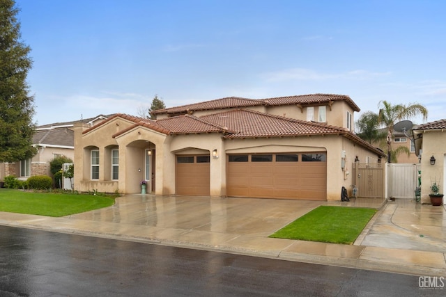 mediterranean / spanish-style house with a tiled roof, a gate, an attached garage, and stucco siding