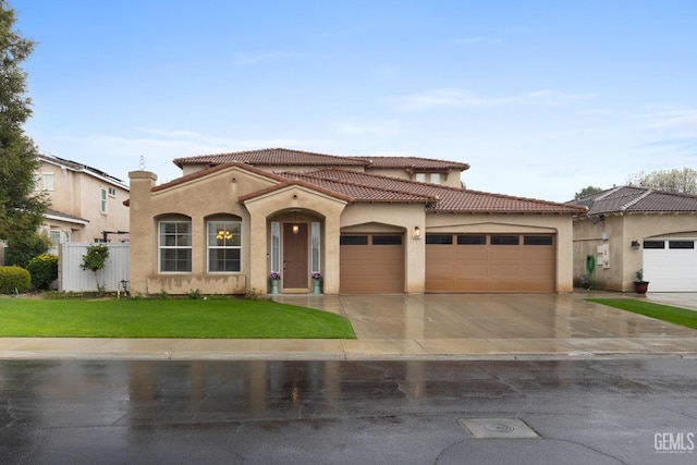 mediterranean / spanish home featuring stucco siding, a tile roof, and a garage