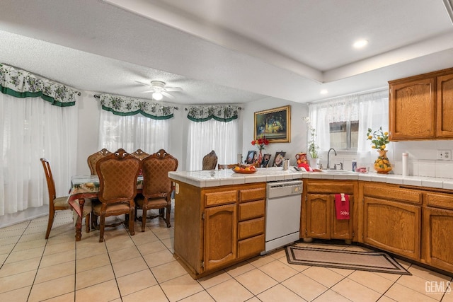 kitchen featuring ceiling fan, dishwasher, kitchen peninsula, tile countertops, and a textured ceiling