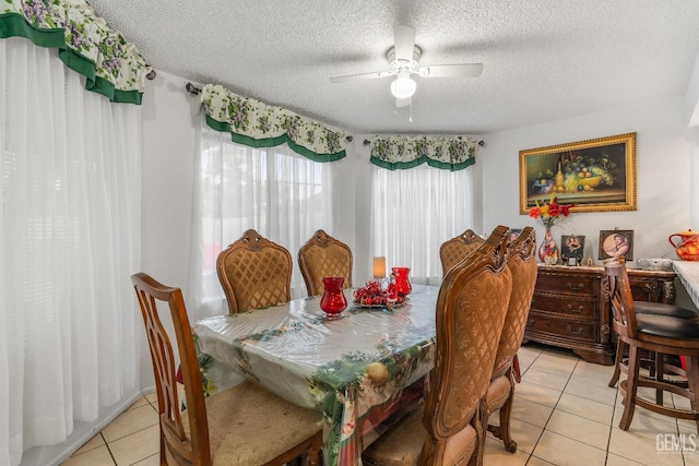 dining space with ceiling fan, light tile patterned floors, and a textured ceiling