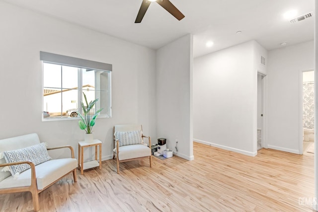 sitting room with ceiling fan and light wood-type flooring