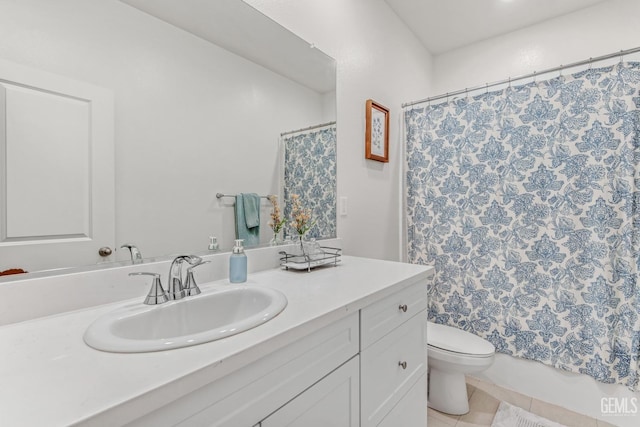 bathroom with tile patterned flooring, vanity, and toilet