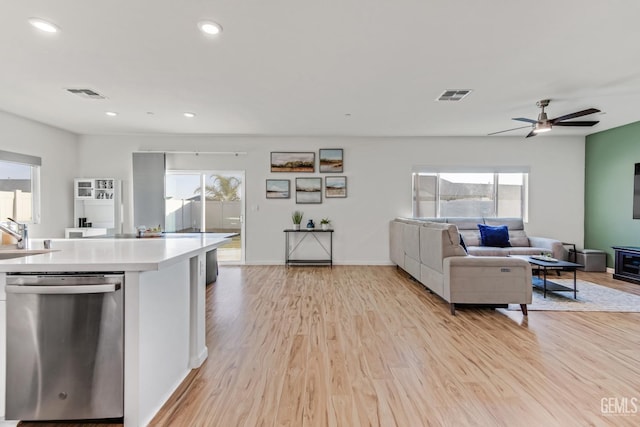 kitchen featuring plenty of natural light, sink, stainless steel dishwasher, and light hardwood / wood-style flooring