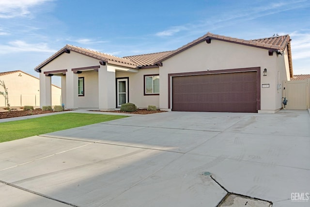 mediterranean / spanish-style home featuring a garage and a front lawn