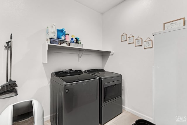 clothes washing area with washing machine and dryer and light tile patterned floors