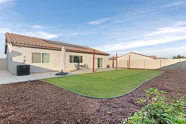 back of property featuring a yard, central AC unit, and a patio area