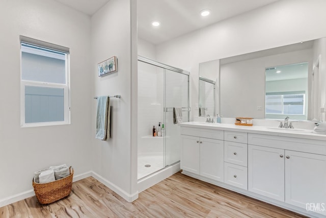 bathroom with vanity, hardwood / wood-style floors, and a shower with shower door