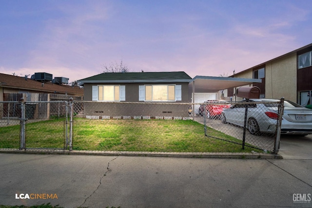 view of front facade with a fenced front yard, a front yard, a gate, an attached carport, and driveway