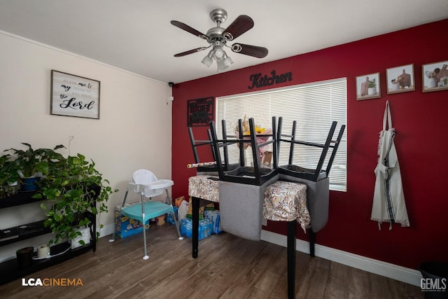 dining area with wood finished floors, a ceiling fan, and baseboards