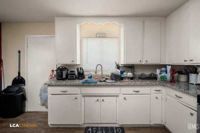 kitchen featuring a sink and white cabinets