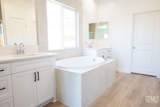 16615 Chloe Ct, Bakersfield, CA 93314 - bathroom featuring a sink, a bath, wood finished floors, and two vanities
