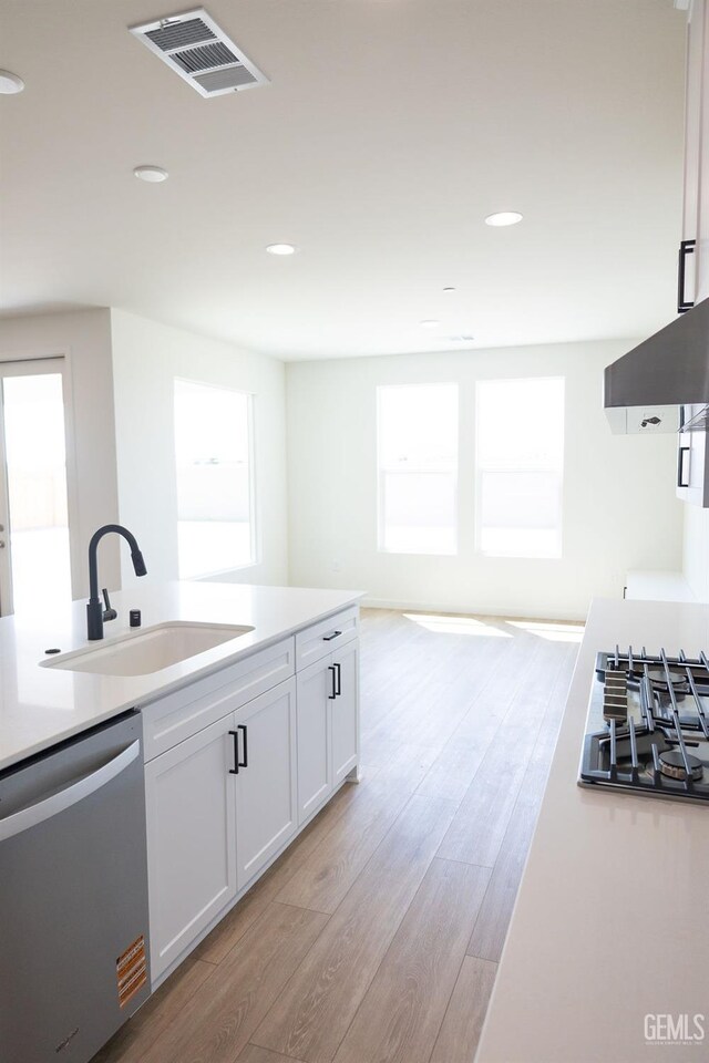 16615 Chloe Ct, Bakersfield, CA 93314 - kitchen featuring visible vents, extractor fan, white cabinetry, a sink, and appliances with stainless steel finishes