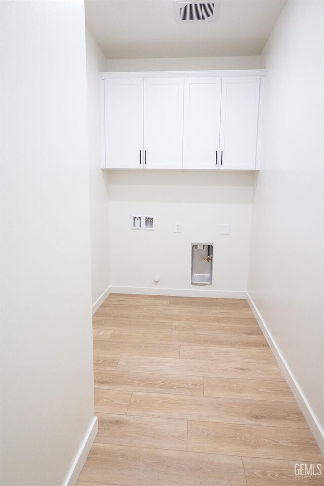 16615 Chloe Ct, Bakersfield, CA 93314 - clothes washing area with visible vents, hookup for a gas dryer, light wood-type flooring, cabinet space, and hookup for a washing machine