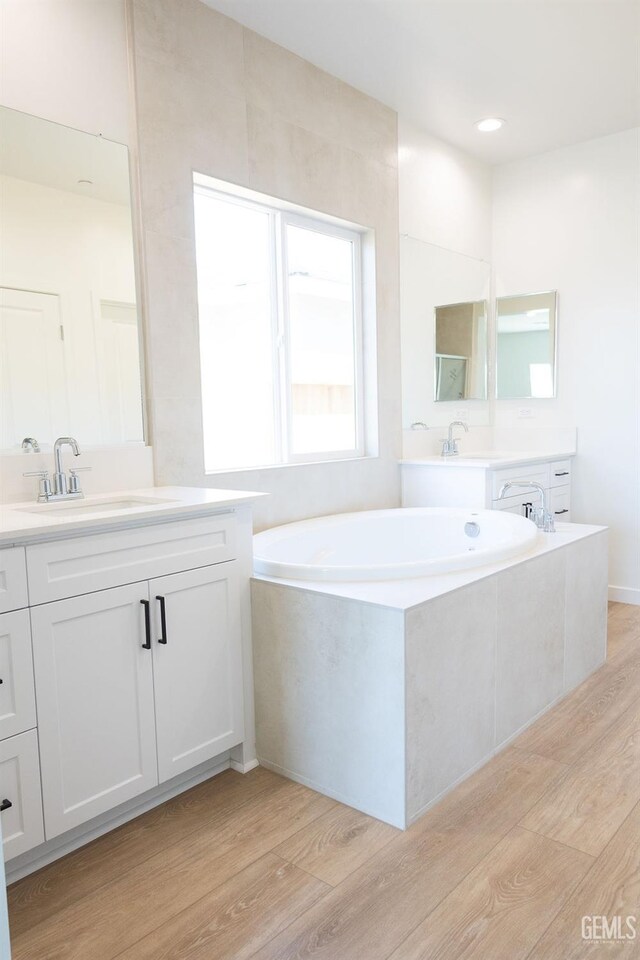 16615 Chloe Ct, Bakersfield, CA 93314 - bathroom featuring vanity, a bath, and wood finished floors