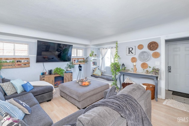 living room featuring light wood-type flooring and a textured ceiling