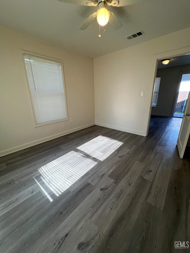 empty room with ceiling fan and dark hardwood / wood-style floors