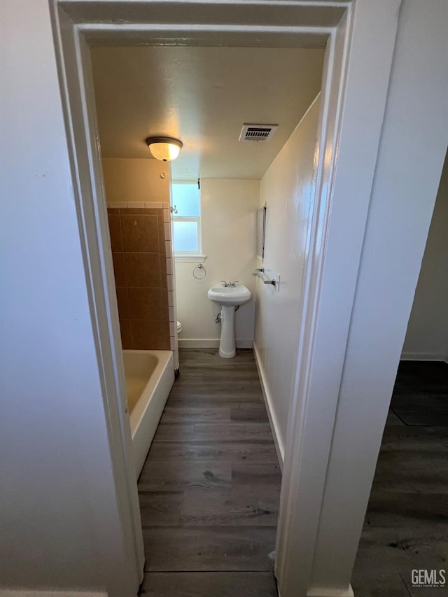 bathroom with hardwood / wood-style flooring, toilet, and shower with separate bathtub