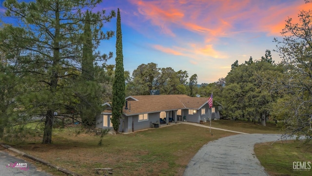 view of front of house with a lawn, stucco siding, and aphalt driveway