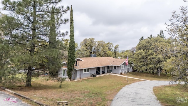 view of front of home featuring aphalt driveway, stucco siding, and a front yard