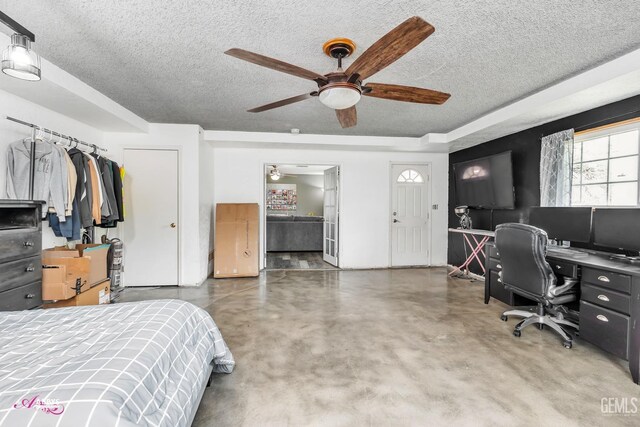 bedroom featuring a textured ceiling, ceiling fan, and finished concrete flooring