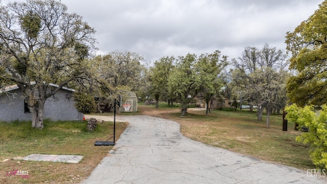surrounding community with a yard and aphalt driveway