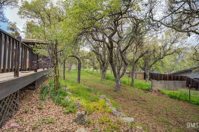 view of yard featuring a deck and fence