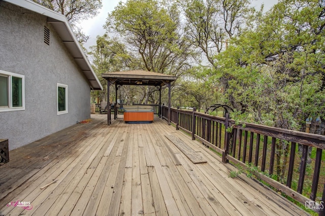 wooden terrace with a hot tub and a gazebo