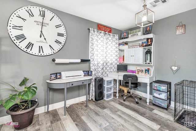 home office with baseboards, wood finished floors, and visible vents