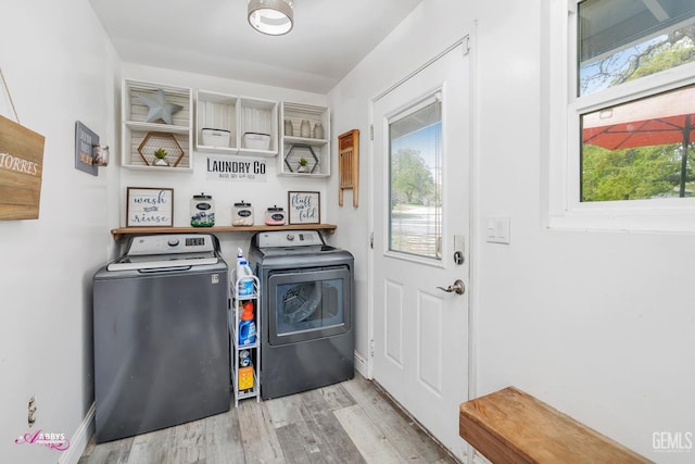 laundry area featuring a wealth of natural light, laundry area, wood finished floors, and washing machine and clothes dryer