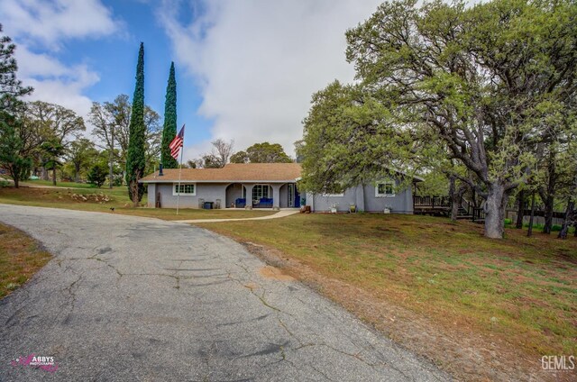 ranch-style home featuring stucco siding, driveway, and a front lawn