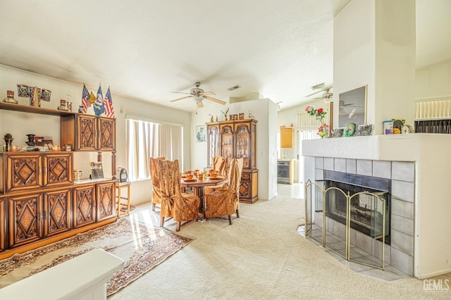 interior space featuring light carpet, ceiling fan, a tile fireplace, and a healthy amount of sunlight