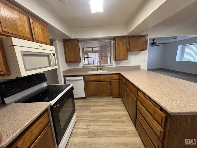 kitchen featuring sink, white appliances, light wood-type flooring, kitchen peninsula, and ceiling fan