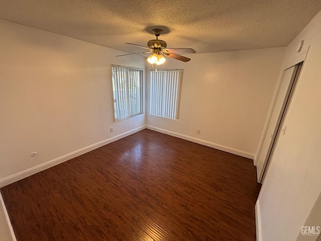 unfurnished room with ceiling fan, dark hardwood / wood-style floors, and a textured ceiling