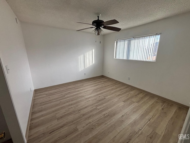 empty room featuring ceiling fan, light hardwood / wood-style floors, and a textured ceiling