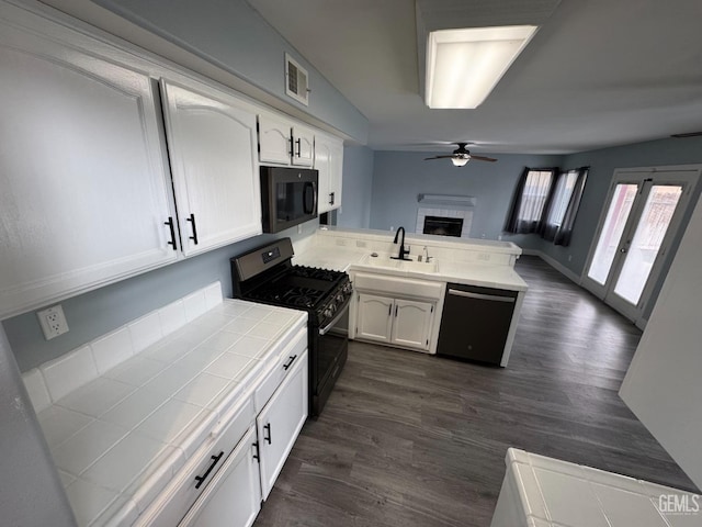 6100 Aruba Ct, Bakersfield, CA 93313 - kitchen featuring dishwashing machine, stainless steel range with gas cooktop, a peninsula, tile counters, and black microwave