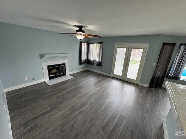 6100 Aruba Ct, Bakersfield, CA 93313 - unfurnished living room with baseboards, ceiling fan, dark wood finished floors, a tiled fireplace, and french doors