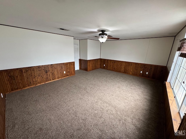6100 Aruba Ct, Bakersfield, CA 93313 - empty room with light carpet, a wainscoted wall, ceiling fan, and wooden walls