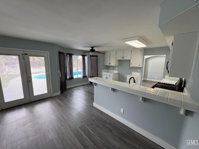 6100 Aruba Ct, Bakersfield, CA 93313 - kitchen featuring range, a peninsula, dark wood-type flooring, and tile counters