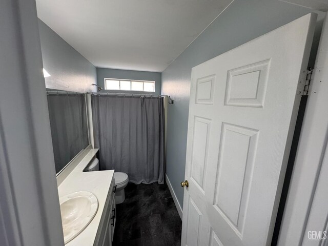6100 Aruba Ct, Bakersfield, CA 93313 - bathroom featuring a shower with shower curtain, baseboards, toilet, and vanity