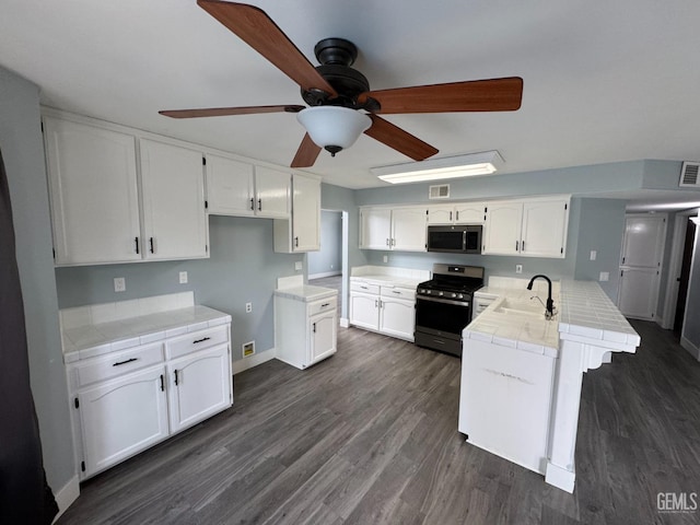 6100 Aruba Ct, Bakersfield, CA 93313 - kitchen with a ceiling fan, a sink, white cabinetry, stainless steel appliances, and a peninsula